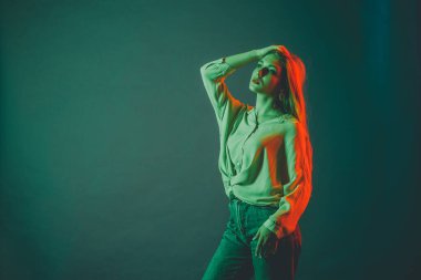 Güzel bir kadın modelin yaratıcı portresi. Stüdyoda turuncu ve yeşil ışık.