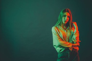 Güzel bir kadın modelin yaratıcı portresi. Stüdyoda turuncu ve yeşil ışık.