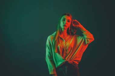 Güzel bir kadın modelin yaratıcı portresi. Stüdyoda turuncu ve yeşil ışık.