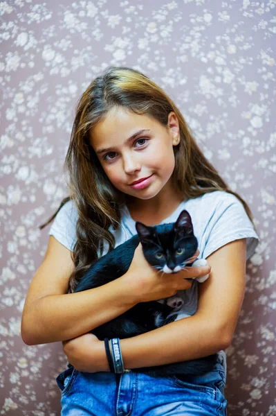 女の子10歳と黒と白の子猫 美しいブルネットの女の子と黒猫 — ストック写真