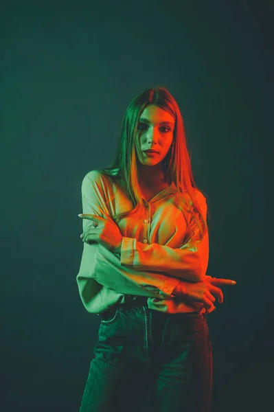 Creative portrait of a beautiful female model close-up. orange and green lighting in the Studio.