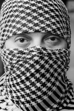 Arafatka 'daki bir adamın gözleri. Arafatka 'daki adam. Siyah beyaz arafatka giymiş esmer bir adamın portresi.