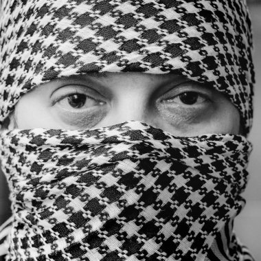Arafatka 'daki bir adamın gözleri. Arafatka 'daki adam. Siyah beyaz arafatka giymiş esmer bir adamın portresi.