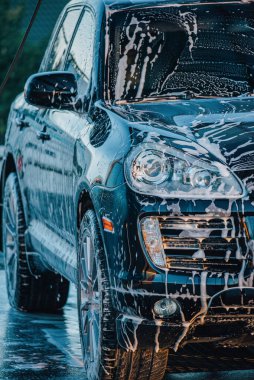 Arabayı yıka. Araba yıkamada siyah bir araba yıkamak.