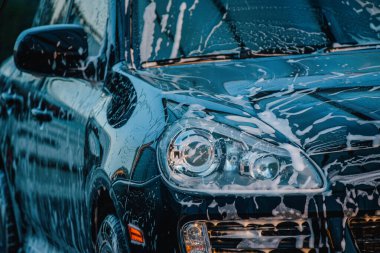 Arabayı yıka. Araba yıkamada siyah bir araba yıkamak.