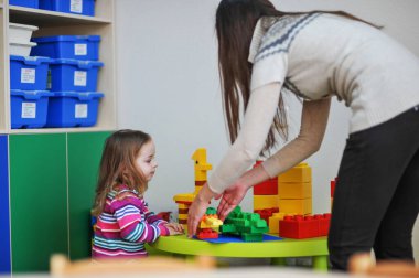 Oyuncaklı mutlu küçük kız. Oyun odasında oynayan küçük kız. Çocuk ve inşaatçı