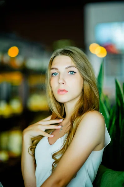 一个蓝眼睛的女孩坐在城市咖啡馆里 棕色波浪形头发的女人 生活方式概念 — 图库照片