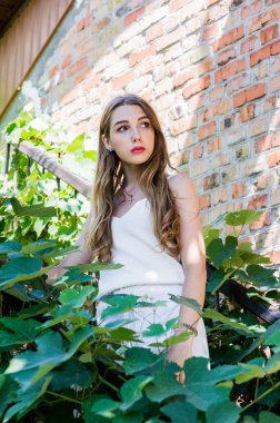 Sokakta yürüyen güzel, şık bir kızın portresi. Yazın beyaz elbiseli kız.