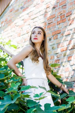 Sokakta yürüyen güzel, şık bir kızın portresi. Yazın beyaz elbiseli kız.