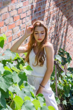 Sokakta yürüyen güzel, şık bir kızın portresi. Yazın beyaz elbiseli kız.