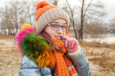 Kışlık giysiler giyen güzel bir kadın. Ceketli ve şapkalı genç kız. Okul çağındaki kız.