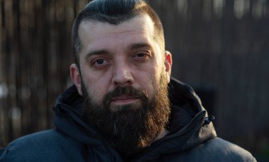 Sokakta gri ceketli sakallı bir adam. Bir adamın portresi. Sakallı adam..