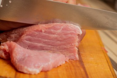 Kasap mutfakta domuz eti kesiyor. Domuz eti ve bıçak. Yemek hazırlığı
