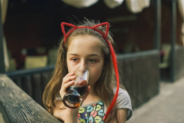 迷人有趣的小女孩在餐馆里喝酒 女孩在夏日街上的咖啡店里喝一杯 — 图库照片