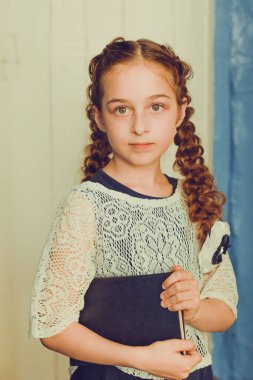 Okula ve eğitim konseptine geri dönmek. Okul üniformalı, örgülü bir öğrenci. 9 yaşında bir kız..