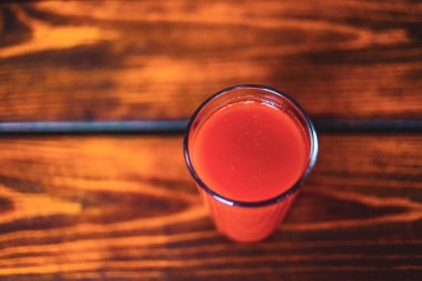 Tahta bir masada domates suyu. Sağlıklı organik gıda konsepti. Boşluğu kopyala