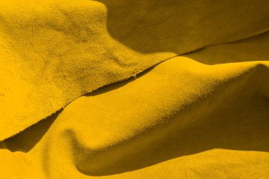 Dikensiz deriden kadife sarısı dokular. Keçeleşmiş makro. Sarı süet kumaş. deri