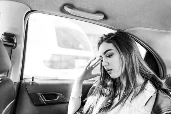 Concept: transport, lifestyle, fashion. Pensive girl in the car.