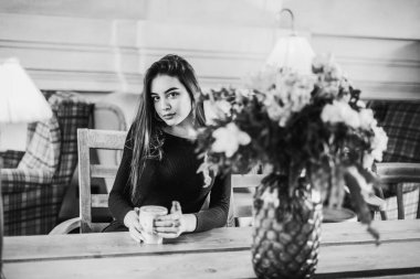 Bir fincan çay ya da kahveli güzel bir kadın. Kafedeki bir kızın siyah-beyaz fotoğrafı. Esmer.