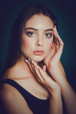 Elleri yüzüne yakın genç ve güzel bir kadının portresi. Genç esmerin güzel yüzü