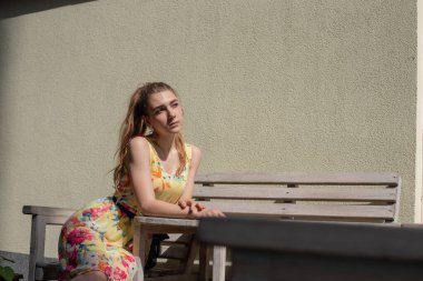 Elbiseli kız yazın eski kasabada yürür. Güzel sarışın kadın yaz fotoğrafı..