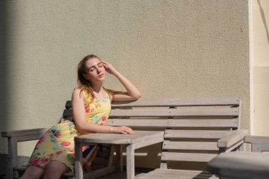 Elbiseli kız yazın eski kasabada yürür. Güzel sarışın kadın yaz fotoğrafı..