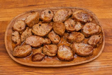 Ahşap bir tabakta kızarmış et parçaları. Biftek, lezzetli, taze. Kızarmış domuz.