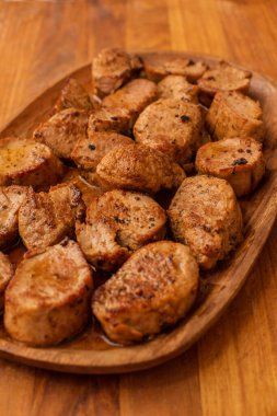 Ahşap bir tabakta kızarmış et parçaları. Biftek, lezzetli, taze. Kızarmış domuz.