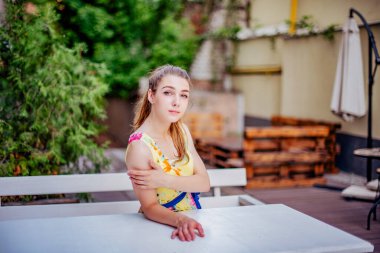 Elbiseli kız yazın eski kasabada yürür. Güzel sarışın kadın yaz fotoğrafı..