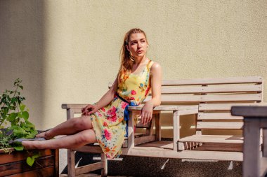 Elbiseli kız yazın eski kasabada yürür. Güzel sarışın kadın yaz fotoğrafı..