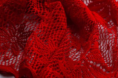 Örülmüş dantel. Madde rasgele yatay bir yüzeyde katlanır. Kumaş örneği. kırmızı dantel