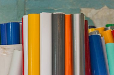 Renkli vinil araba ambalajı ya da etiketli film ruloları. Reklam için rulo şeklinde filmler.