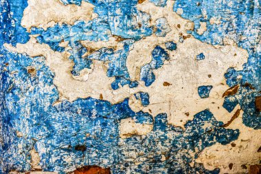 Çizik ve çatlaklarla dolu bir duvar parçası. Mavi duvarlı eski püskü beyaz. Eski, desen