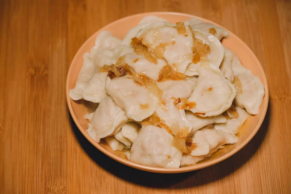 饺子和油炸洋葱一起放在碗里 饺子里塞满了土豆泥和油炸洋葱 — 图库照片