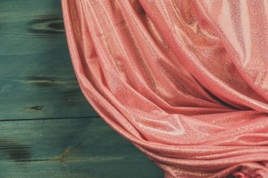 Pembe parıltılı kumaş ve ahşap yeşil arka plan