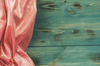 Pembe parıltılı kumaş ve ahşap yeşil arka plan