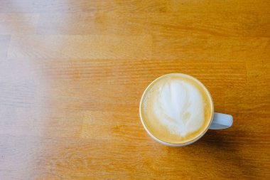 Ahşap bir masada bir fincan kapuçino. Masa kahve kapuçino, bardak süt ahşap.