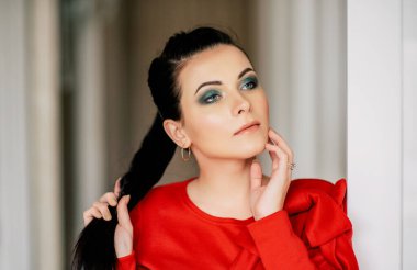 İç kısımda kırmızı elbiseli genç bayan. Kırmızı elbiseli, at kuyruklu esmer kız.