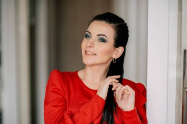 İç kısımda kırmızı elbiseli genç bayan. Kırmızı elbiseli, at kuyruklu esmer kız.