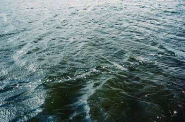 Su, göl, dalga, arka plan. Nehir suyu dokusu. Nehirdeki parlak ve yansıtıcı yüzey suyu.