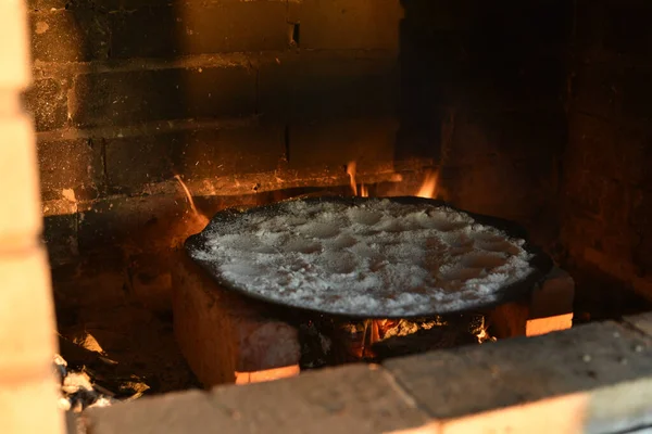 暖炉で塩でフライパンを炒める 塩焼きでフライパンを火にかける — ストック写真
