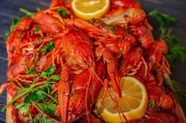 Siyah arka planda kaynamış kerevit, otlar ve limon suyu. Haşlanmış lezzetli kerevit.