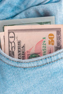 Cebinde Amerikan doları banknotları olan modaya uygun kot pantolonlar. Kot içinde dolar. Mali konsept.