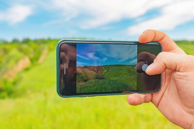 Akıllı bir telefonla fotoğraf çekmek. Elindeki akıllı telefon aleti doğanın resimlerini çekiyor. Doğa.