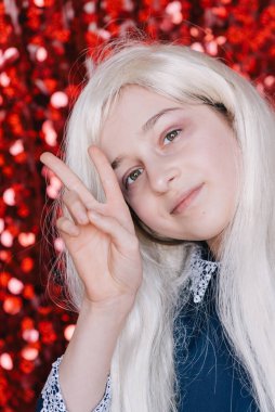 Sarışın. Kırmızı arka plan portresindeki liseli kız. Duygusal kızların bir dizi portresi..