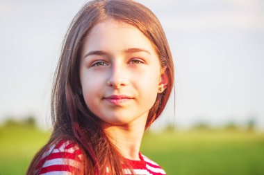 Yazın doğanın arka planında genç bir kızın portresi.