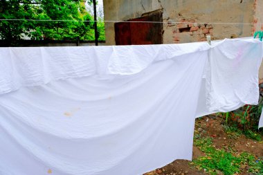 Çarşaflar bir ipe asılı ve kuru.