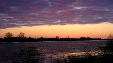 Gün batımında ev ve ağaçların siluetleri