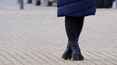 Kaldırımda duran bir kızın bacakları.