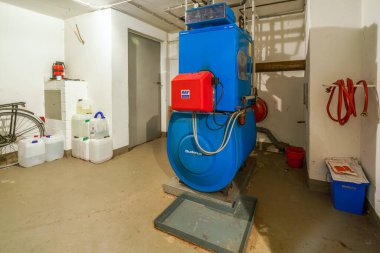 Eski mavi Buderus G 105 yağ ısıtıcısı ve 1992 'de yapılmış kırmızı Ray ocağı.